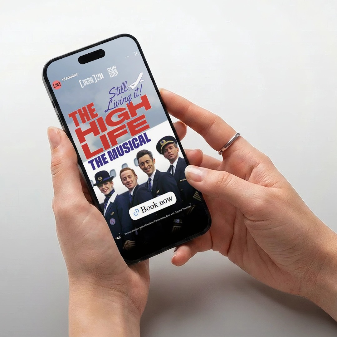 A hand holding a phone showing 'The High Life: The Musical' advert