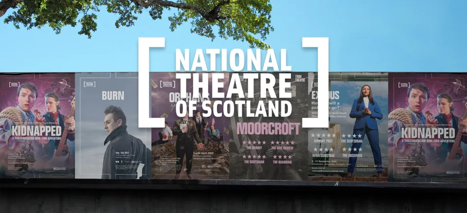 A brick wall displaying a collage of National Theatre of Scotland posters, including Kidnapped, Burn (starring Alan Cumming), Orphans, Moorcroft, and Exodus.