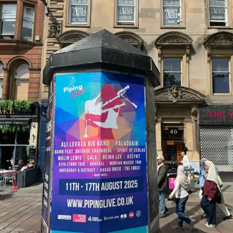 Street poster on a pillar advertising the "Piping Live!" festival in Glasgow, taking place August 11th–17th, 2025
