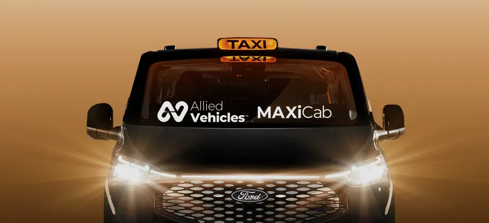 Front of the Allied Vehicles MAXICab taxi with its headlights on