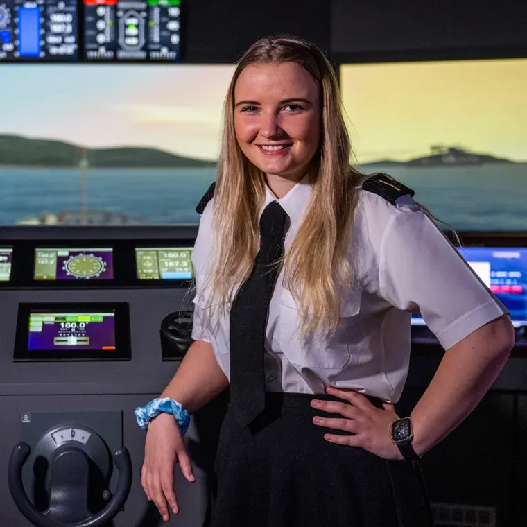 A City of Glasgow College nautical student in uniform at a ship's bridge simulator
