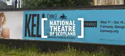 A horizontal outdoor printed billboard advertisement for the National Theatre of Scotland production of Keli on Wed 11 – Sat 14 June at Tramway, Glasgow.