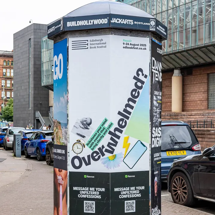 A printed poster on a city pillar featuring a banner with the diagonal text Overwhelmed? As part of the Edinburgh International Book Fest 2025 Repair campaign