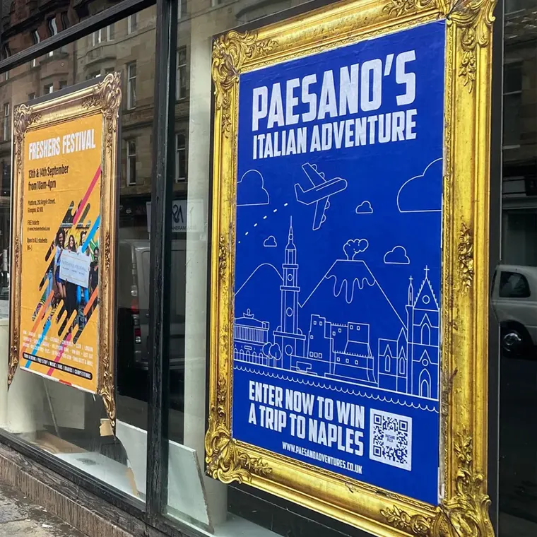 A 'Paesano's Italian Adventure' poster in a gold frame: 'Enter now to win a trip to Naples'