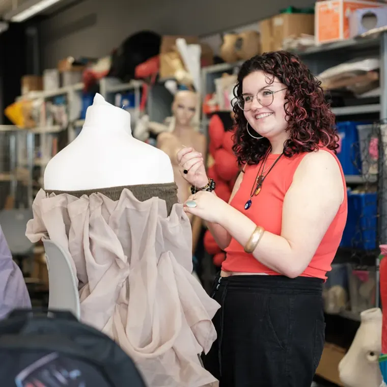 A City of Glasgow College fashion student draping fabric on a mannequin