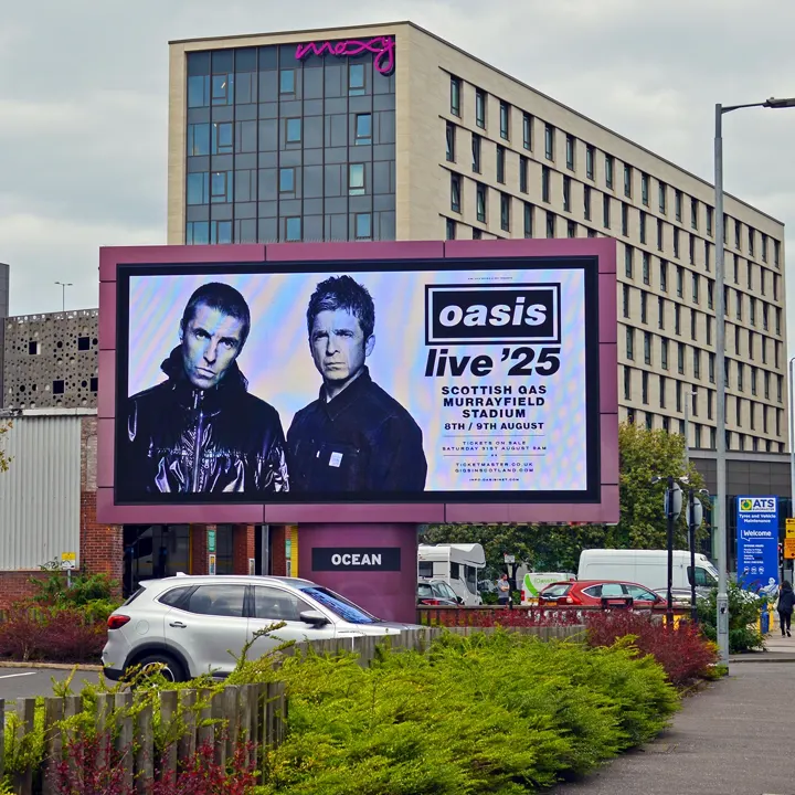 A digital billboard advertisement for Oasis live '25. The screen features a black-and-white photo of Liam and Noel Gallagher and lists dates for Scottish Gas Murrayfield Stadium on 8th and 9th August.