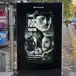 A digital street billboard at a bus stop displaying a black-and-white advertisement for the National Theatre of Scotland's production of The Strange Case of Dr Jekyll & Mr Hyde.