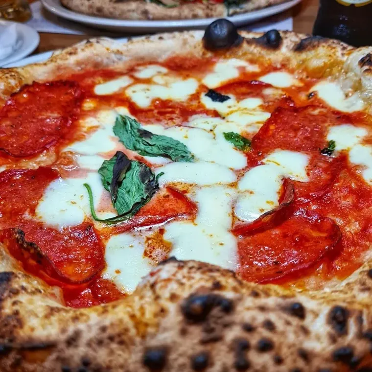 Close-up of a Paesano Neapolitan pizza with tomato, mozzarella, pepperoni and basil