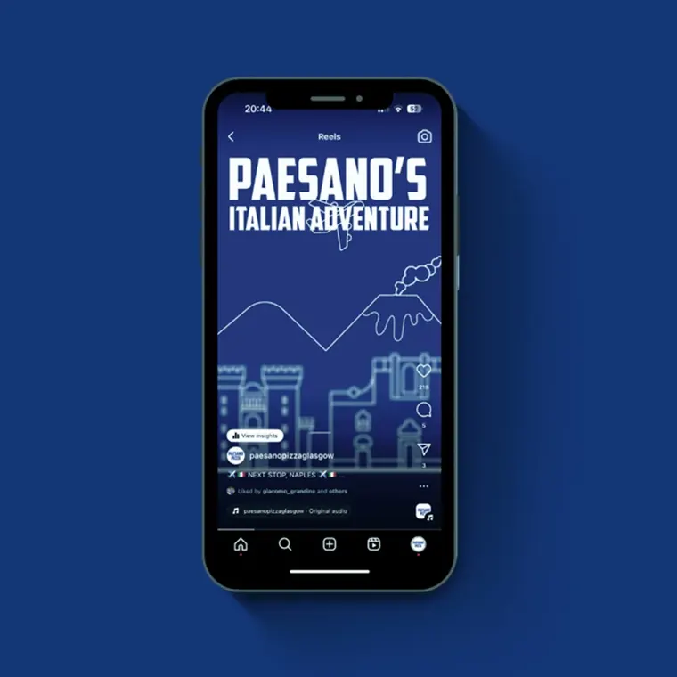 A phone showing a 'Paesano's Italian Adventure' Instagram reel