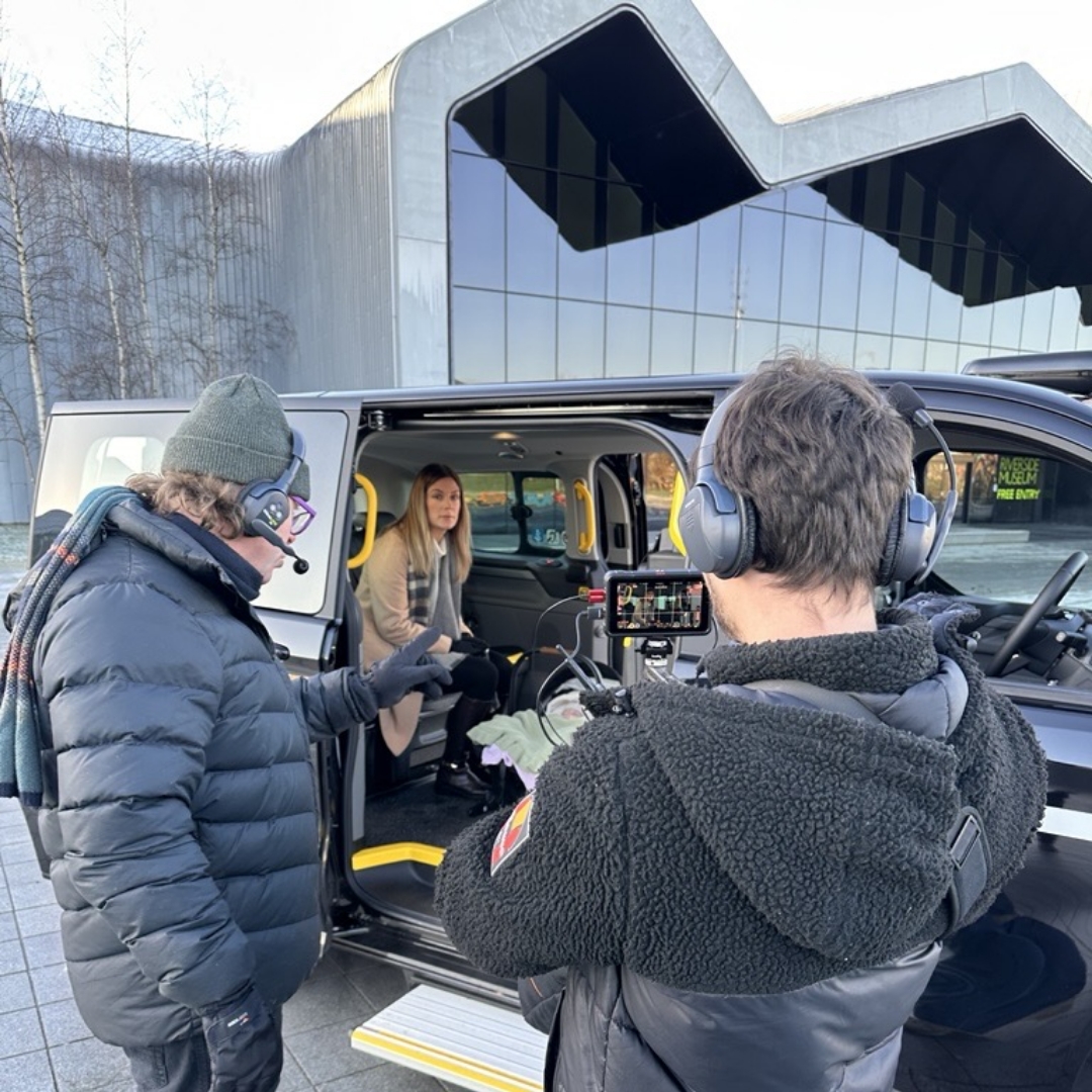Film crew in headphones recording a passenger inside a MAXICab taxi at the Riverside Museum, Glasgow