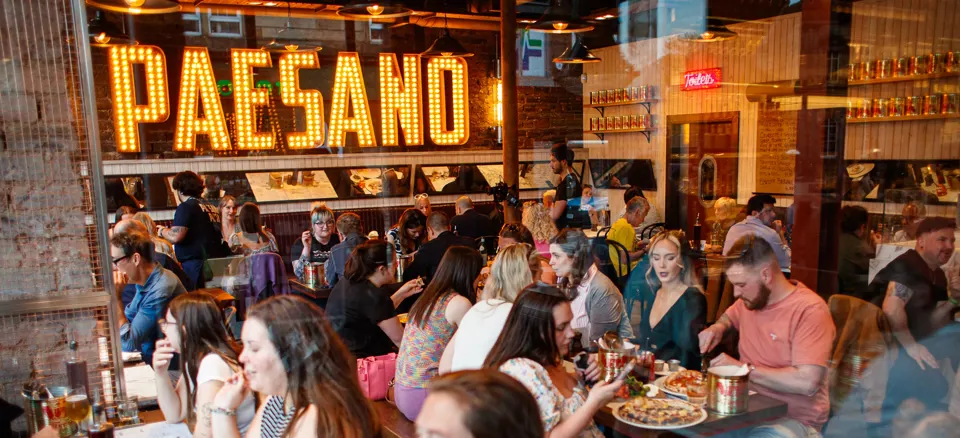 The official opening of the new Paesano Pizza branch in the Southside, filled with people enjoying their food and drinks