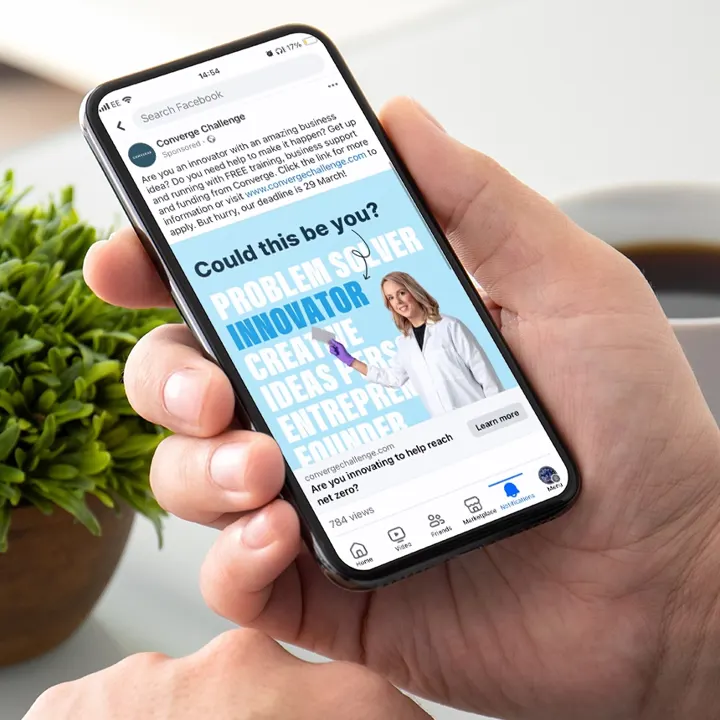 A smartphone displaying a Converge Challenge sponsored post with the headline Could This Be You? Promoting their innovation competition.