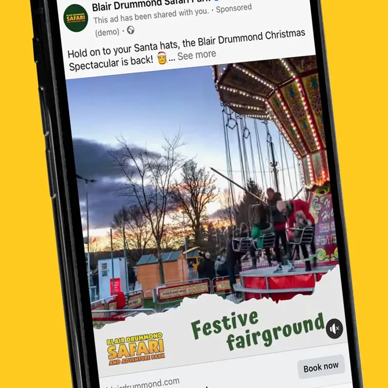 A phone showing a Blair Drummond Christmas Spectacular advert for the festive fairground