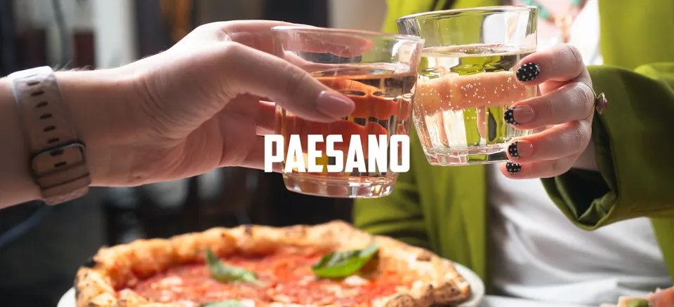 Paesano Pizza banner image with 2 women enjoying drinks and pizza in the restaurant