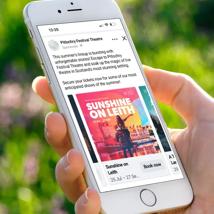A phone showing a Pitlochry Festival Theatre Facebook advert for 'Sunshine on Leith'