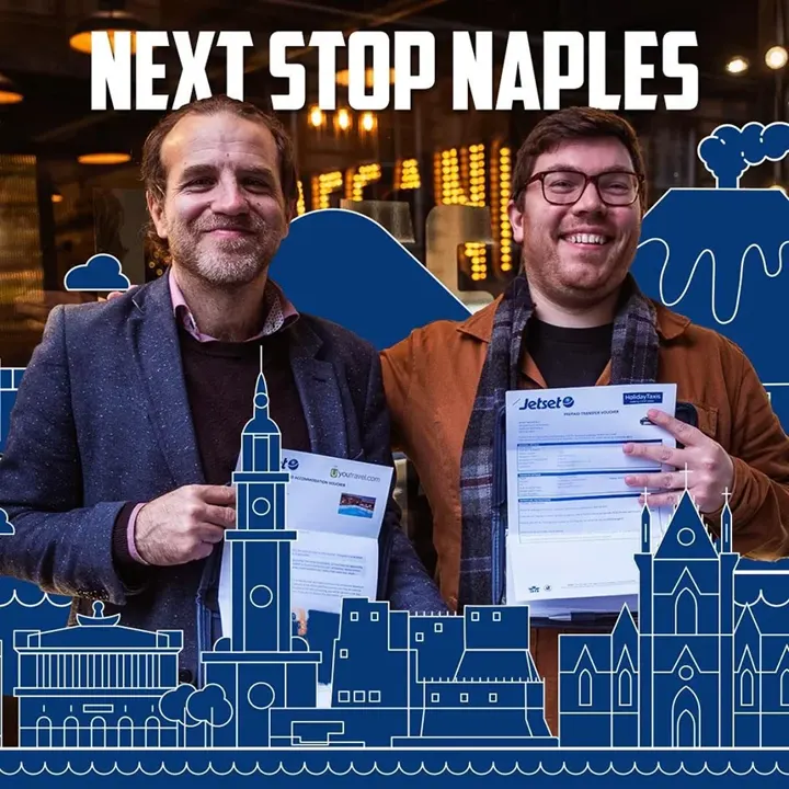 Two men holding travel tickets for the 'Next Stop Naples' Paesano competition
