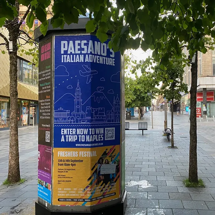 A 'Paesano's Italian Adventure' poster on a street column in a pedestrianised Glasgow street