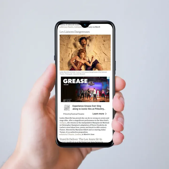 A phone showing a Pitlochry Festival Theatre 'Grease' advert on a news website