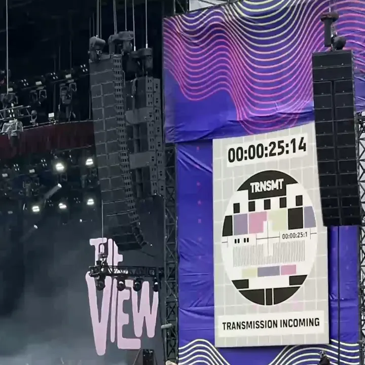 A concert stage at the TRNSMT festival featuring a screen displaying a television test card with the TRNSMT logo and a digital countdown timer at the top.