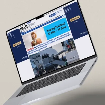 An open laptop displaying the MailOnline website, featuring a prominent blue and white National Theatre of Scotland banner advertisement for the upcoming performance of Keli.