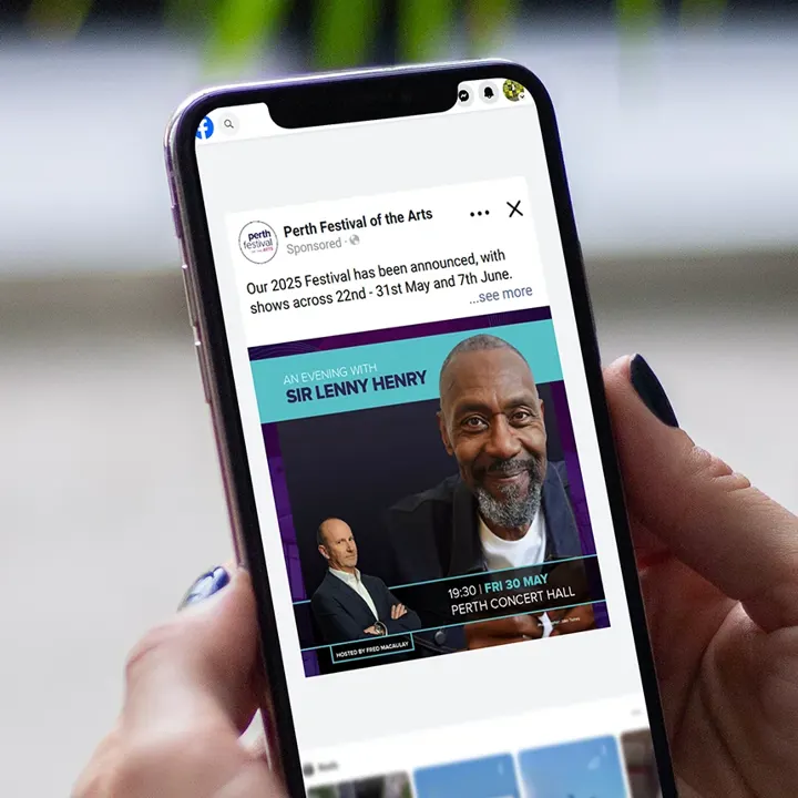 A phone showing a Perth Festival of the Arts Facebook advert for 'An Evening with Sir Lenny Henry'