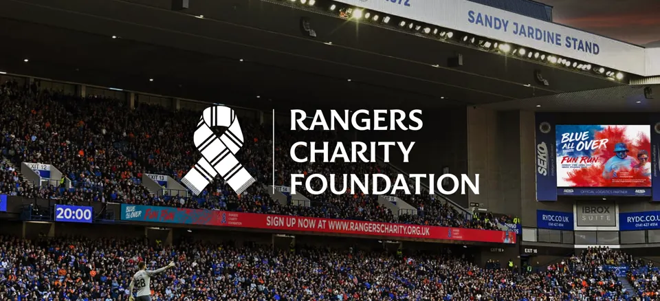 Rangers Charity Foundation logo over a view of Ibrox Stadium during a match